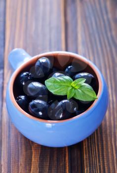 black olives in bowl and on a table