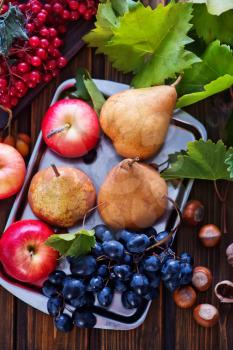 autumn fruits on the wooden table, apples and grape