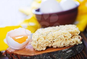 raw egg noodles on the wooden board