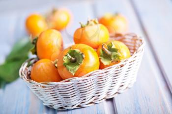 persimmon in basket and on a table