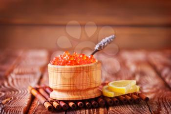 red salmon caviar in bowl and on a table