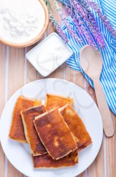 pancakes with cottage and sour cream on a table