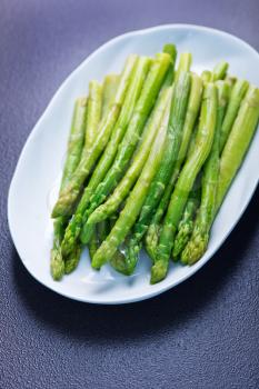 green asparagus, fresh asparagus on plate and on a table