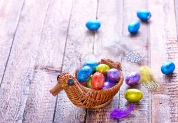 chocolate eggs in color foil and on a table