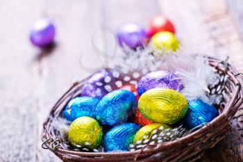 chocolate eggs in color foil and on a table