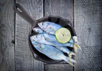 raw fish with lemon on the pan and on a table