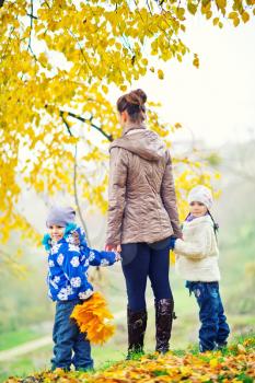mother and her doughters in autumn park