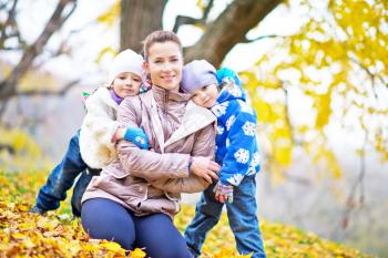 mother and her doughters in autumn park