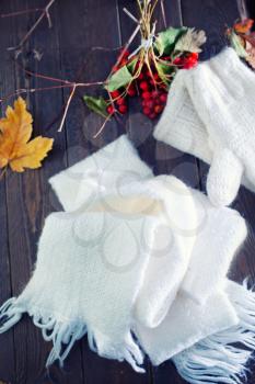 white mittens and scarf on the wooden table
