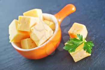 cubes of cheese in the bowl and on a table