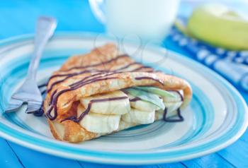 pancakes with chocolate and banana on the plate