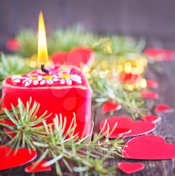 red candle and christmas decoration on the wooden table
