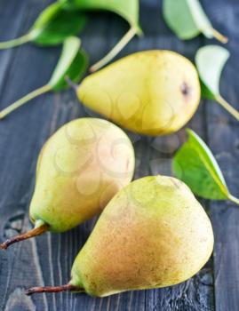fresh pears and leaves on the wooden table
