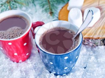 cocoa drink in red cup and on white snow