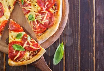 fresh pizza with tomato on the wooden table