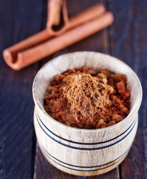 dry cinnamon in the wooden bowl and on a table