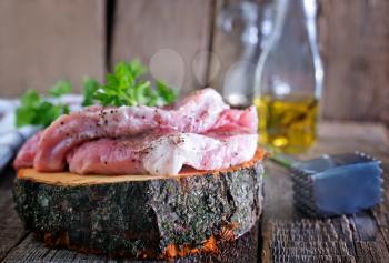 raw meat on the wooden board and on a table