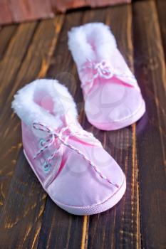baby shoes on the wooden table, pink shoes