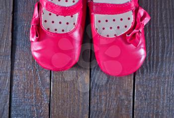 red baby shoes on the wooden background