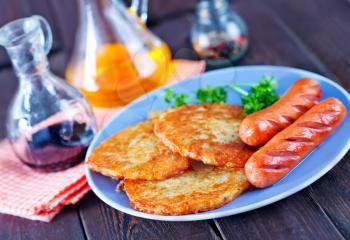 breakfast on a table, pancakes and fried sausages