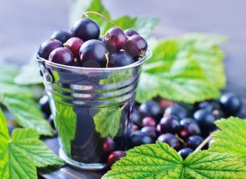 black currant and leaves on the wooden table