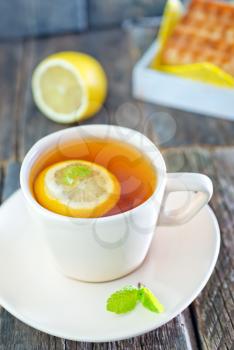 tea with lemon and sweet waffle on a table