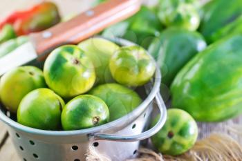 green tomato and pepper on the wooden table