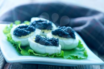 boiled egg with black caviar on plate