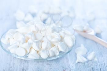 Meringue cookies on plate and on a table