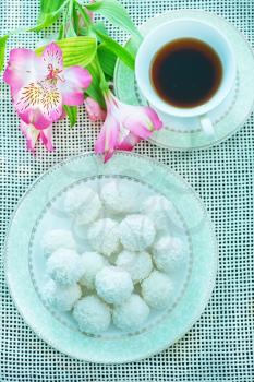 coconut balls on the white plate and on a table