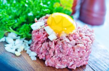 minced meat with yolk on the board