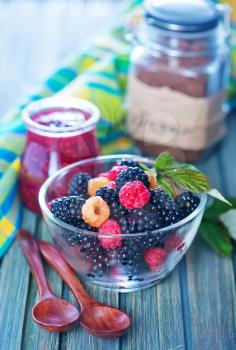fresh berries in glass bowl and on a table