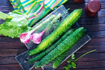 fresh cucumbers on board and on a table