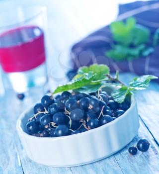 fresh black currant in bowl and on a table