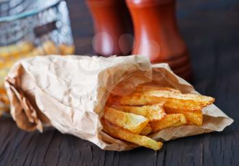 fried potato in paper bag and on a table