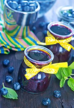 blueberry jam in glass bank and on a table