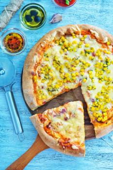 fresh pizza with cheese and corn on the board