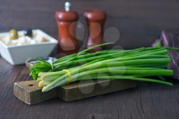 fresh onion on wooden board and on a table