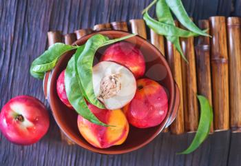 fresh nectarine in bowl and on a table