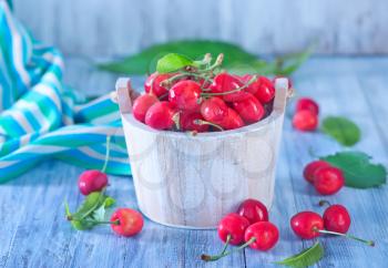 fresh cherry in white bowl and on a table