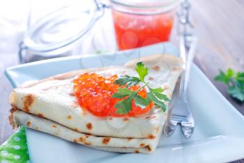 pancakes with salmon caviar on a table