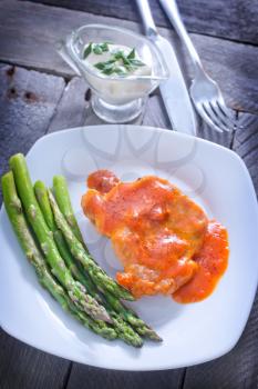 fried meat with sauce and asparagus