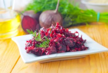 Fresh salad with beet and walnuts on white plate