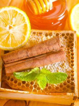 Honey with fresh mint and cinnamon on wooden board