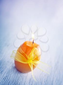 Orange candle on the table, burning candle