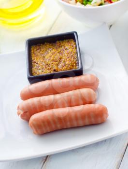 The sausages with the mustard, sausages in  white plate