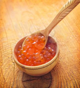 Red salmon caviar in the wooden bowl and spoon