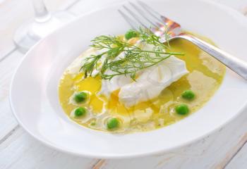 Fresh soup from green peas and egg-poached