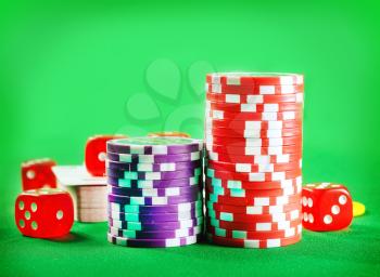 Chips for poker and cubes on the green background