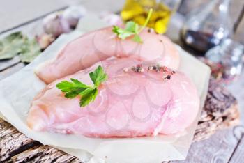 raw chicken fillet on board and on a table